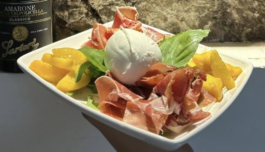 Creamy burrata served with slices of prosciutto
