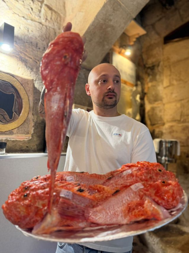 A staff member presenting a fresh whole rockfish